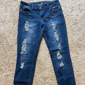 Almost Famous mid rise skinny jeans with holes on front of legs. Size 11.